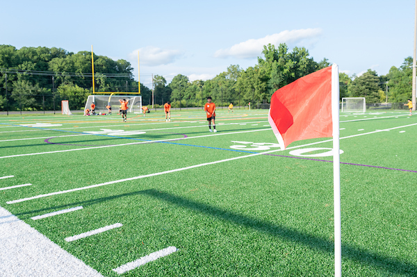 Soccer players on field with a red flag